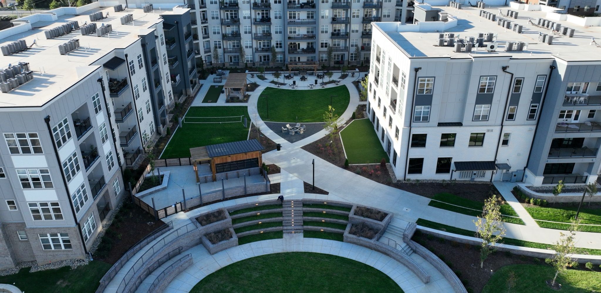 View of expansive apartment pool amenity with built-in seating