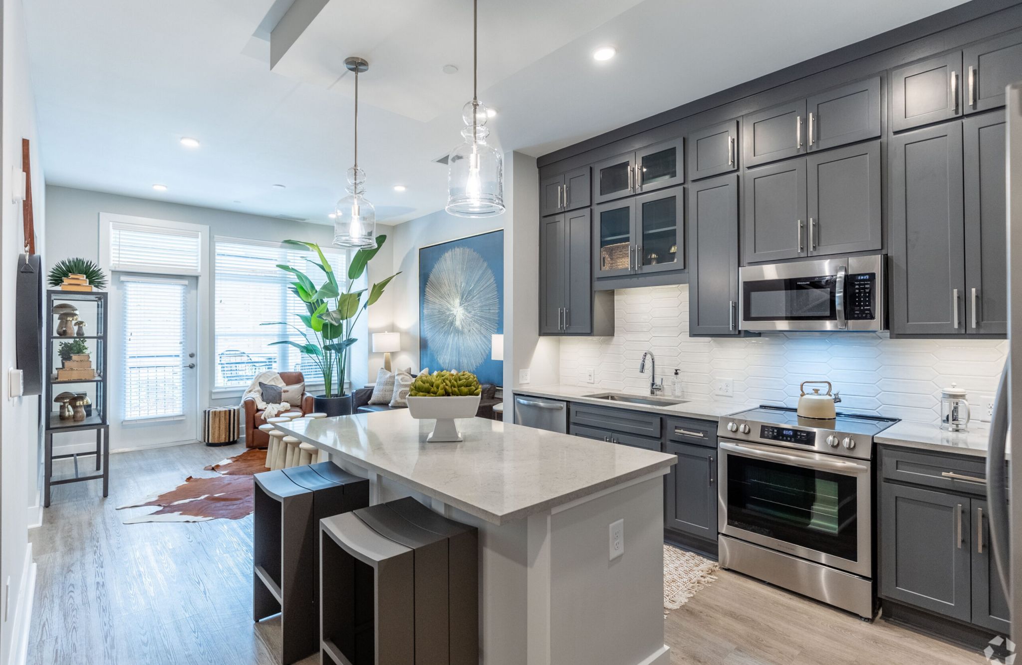 McEwen Apartments kitchen with dark cabinets, island, and stainless steel appliances